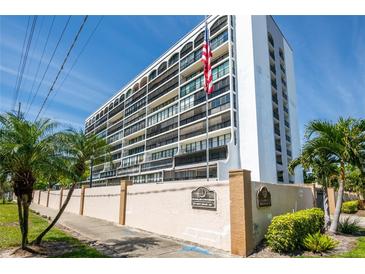 The Penland Condominium exterior showcasing a multi-story building with an American flag and lush landscaping at 3211 W Swann Ave # 602, Tampa, FL 33609