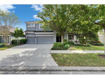 Charming two-story home with a three-car garage, manicured lawn, and mature trees at 6423 Seasound Dr, Apollo Beach, FL 33572