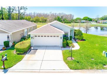 Charming home with lush green lawn, well-manicured landscaping, and attached two car garage at 9426 Green Needle Dr, New Port Richey, FL 34655