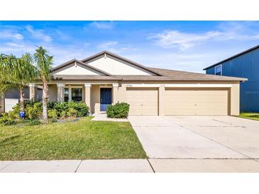 Inviting single-Gathering home with well-maintained lawn, two-car garage, and covered front porch at 9743 Sage Creek Dr, Ruskin, FL 33573