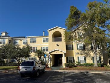 Attractive condo building with yellow siding, green shutters, and manicured landscaping in a well-maintained community at 18575 Bridle Club Dr # 18575, Tampa, FL 33647