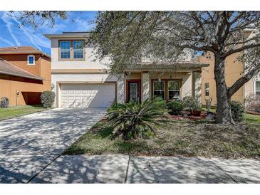 Charming two-story home featuring a well-maintained lawn, inviting front porch, and attached two-car garage at 20220 Autumn Fern Ave, Tampa, FL 33647