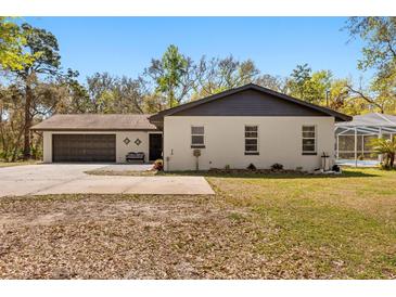 Charming home featuring a two-car garage, and an inviting outdoor area perfect for relaxing and entertaining at 35128 Excalibur Rd, Webster, FL 33597