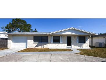 Charming single-story home with a well-maintained front yard, attached garage, and neutral color palette at 3603 Darlington Rd, Holiday, FL 34691