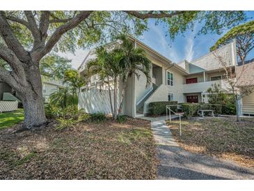 Inviting condo exterior featuring mature landscaping, palm trees, and well-maintained facade at 507 Windrush Bay Dr # 507, Tarpon Springs, FL 34689