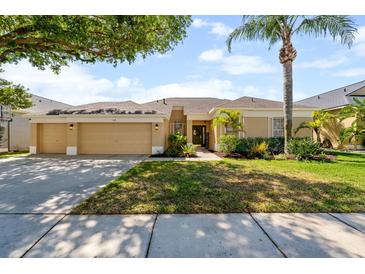 Charming single-story home with a well-manicured lawn, mature landscaping, and a spacious three-car garage at 5123 Whispering Leaf Trl, Valrico, FL 33596