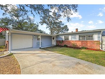 Charming single-story home with brick accents, light blue siding, and a well-maintained front yard at 910 Edgedale Cir, Brandon, FL 33510