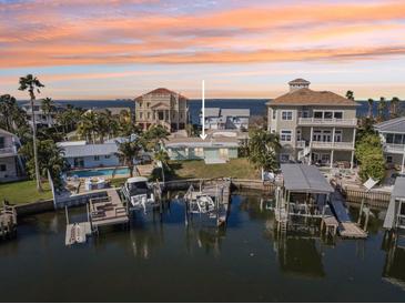 Waterfront home with boat docks and lifts, offering scenic sunset views and easy access to the Gulf of Mexico at 104 Carlyle Cir, Palm Harbor, FL 34683