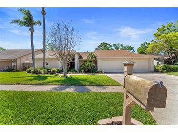 Charming single-story home featuring a well-maintained lawn, mature trees, and a large two car garage at 3442 Beech Trl, Clearwater, FL 33761