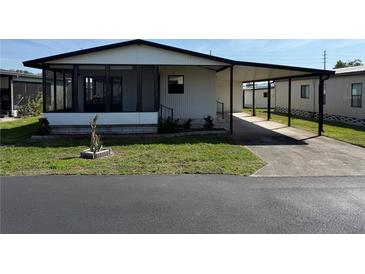 Charming single-story home featuring a carport, screened porch, and well-maintained landscaping at 37542 Pinata Ave, Zephyrhills, FL 33541