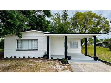 Charming single-story home with a covered porch, manicured lawn, and freshly painted white brick at 4005 W Nassau St, Tampa, FL 33607