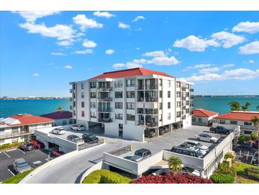 Multi-story condo building with red roof, parking, and water views at 6211 Sun Blvd # 404, St Petersburg, FL 33715