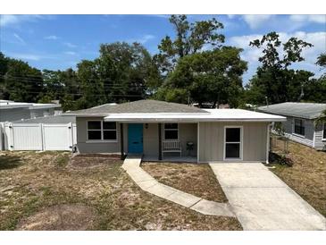 Charming single-story home featuring a bright blue door, well-maintained lawn, and inviting walkway, perfect for first-time buyers at 1312 Tuscola St, Clearwater, FL 33756