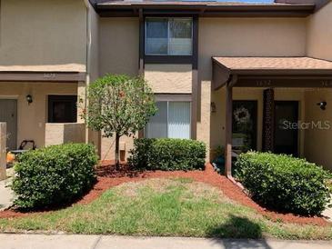 Charming townhome with well-manicured front lawn, mature landscaping, and covered entryway at 3632 Pine Cone Cir, Clearwater, FL 33760