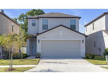 Charming two-story home featuring a two-car garage and well-maintained lawn and landscaping at 7229 Spring Snowflake Ave, Tampa, FL 33619