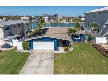 Charming blue home with a well-manicured lawn and a white garage door at 11125 7Th E St, Treasure Island, FL 33706