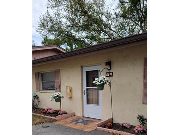Charming entrance with flowers, muted shutters, and a cream colored stucco exterior at 4594 Mohican Trl # 143, Sarasota, FL 34233