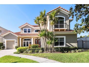 Charming two-story home with a terracotta roof, balcony, manicured lawn, and lush landscaping at 601 Viento De Avila, Tampa, FL 33613
