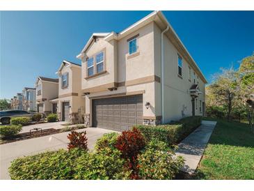 Stylish townhome featuring a stucco exterior, manicured landscaping, and attached two-car garage at 6732 Rocky Park St, Tampa, FL 33625