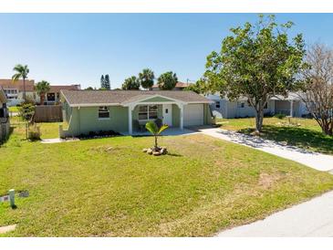 Charming single-story home featuring a well-manicured lawn and an inviting entryway with a small sitting area at 7322 Mako Dr, Hudson, FL 34667