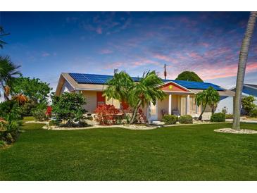 Charming single-story home with solar panels, well-maintained landscaping, and a lush green lawn at 1515 Arrowhead Dr, Sun City Center, FL 33573