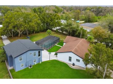 Stunning aerial view of a home with a screened pool and well-manicured green lawn at 20 2Nd Se Ave, Lutz, FL 33549
