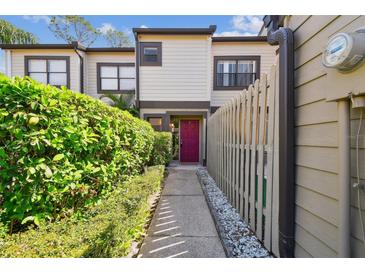 Charming townhome with a colorful entrance, complemented by lush greenery and a well-maintained walkway at 440 Woods Landing Trl, Oldsmar, FL 34677