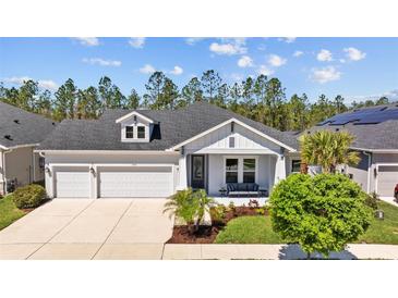 Charming single-story home featuring a 2-car garage, inviting front porch, and manicured landscaping at 3966 Tour Trce, Land O Lakes, FL 34638