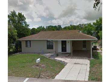 Single-story home featuring a cozy carport and well-maintained front lawn at 7056 Spring Hill Dr, Spring Hill, FL 34606