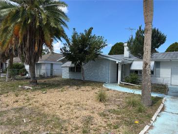 Quaint single story home featuring unique stone accents and mature landscaping at 9741 Scenic Dr, Port Richey, FL 34668