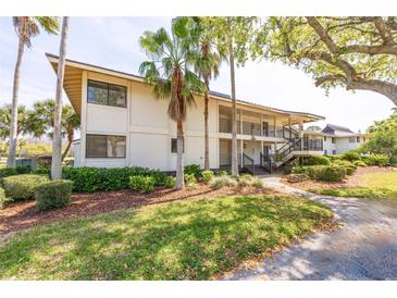 Two-story condo building featuring palm trees and covered staircases at 5020 Mill Pond Rd # 3158 & 3160, Wesley Chapel, FL 33543