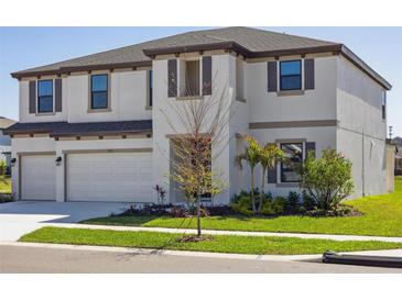 Two-story home with a three car garage, manicured lawn and a neutral color palette at 5335 Wolf Creek Dr, Apollo Beach, FL 33572