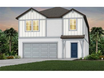 Charming two-story home with white siding, gray trim, a two-car garage, and well-manicured landscaping at 6217 Golden Beach Dr, Apollo Beach, FL 33572