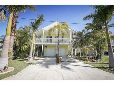 Charming two-story home with white trim, a balcony, a two-car garage, and a beautifully landscaped yard at 112 13Th Ave, Indian Rocks Beach, FL 33785