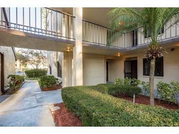 A well-maintained apartment building exterior with landscaped walkway and courtyard view on a sunny day at 2211 Belleair Rd # D12, Clearwater, FL 33764