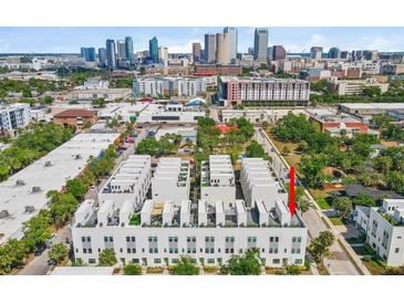 An aerial view showcasing the modern townhome development with a stunning city skyline backdrop at 401 N Oregon Ave # 1, Tampa, FL 33606