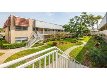 Beautiful condo building with lush green landscaping, offering a serene environment at 10034 64Th N Ave # 14, St Petersburg, FL 33708