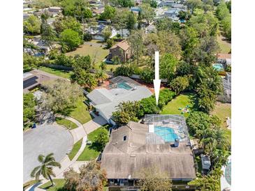 Stunning aerial view of a home with a screened-in pool and lush landscaping in a desirable neighborhood at 13420 Rustic Pines S Blvd, Seminole, FL 33776
