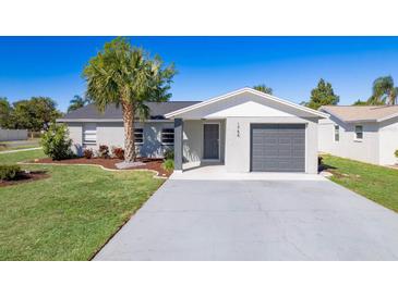 Charming single-story home features a well-manicured lawn, gray exterior paint, and an attached garage at 1766 10Th Sw St, Largo, FL 33778