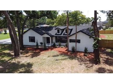 Charming white brick home featuring a well-manicured lawn and mature trees at 2715 Willow Oaks Dr, Valrico, FL 33594
