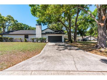 Charming one story home featuring a driveway, mature trees, and painted brick at 2715 Willow Oaks Dr, Valrico, FL 33594