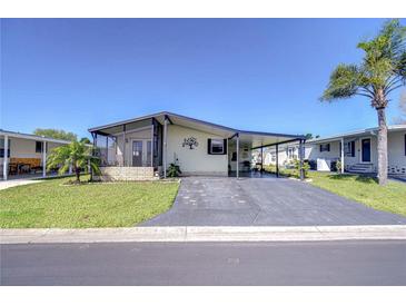 Charming single-story home featuring a covered porch, extended driveway and lush landscaping at 3051 Shady Creek Dr, Wesley Chapel, FL 33543