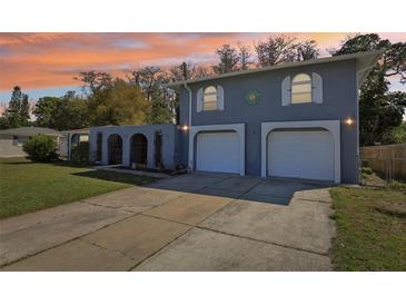 Two-story home with a spacious driveway and an arched privacy wall, plus a two-car garage at 3346 Bainbridge Dr, Holiday, FL 34691