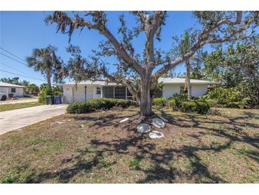 Charming single-story home with mature tree in the front yard and a cozy screened in porch at 823 Bayshore Rd, Nokomis, FL 34275