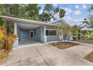 Charming blue home featuring a covered parking area and well-manicured landscaping at 1039 23Rd St, Sarasota, FL 34234