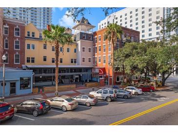 Charming street view of mixed-use building with colorful facades and street parking in a bustling urban setting at 215 Central Ave # 4H, St Petersburg, FL 33701