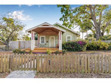 Charming home featuring a well-manicured lawn, delightful front porch, and a quaint wooden fence at 3000 2Nd N Ave, St Petersburg, FL 33713
