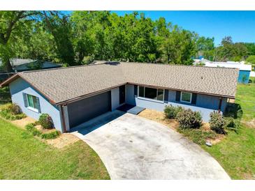 Charming single-story home with a well-maintained lawn and a driveway leading to an attached garage at 37451 Hickory Hill Ln, Dade City, FL 33525