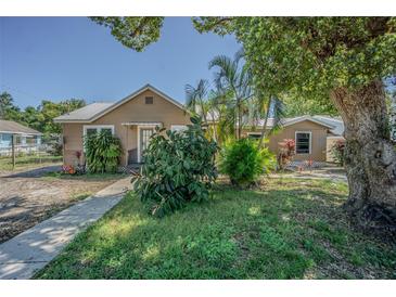 Lovely single-story house with lush greenery and manicured landscaping leading to a cozy front entrance at 8719 N Ola Ave, Tampa, FL 33604
