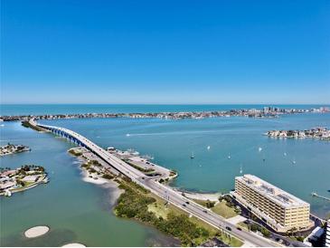 Stunning aerial view showcasing the waterfront property, bridge and expansive ocean views at 100 Bluff View Dr # 117C, Belleair Bluffs, FL 33770